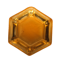 Hexagonal amber-colored tea liquid on a white background